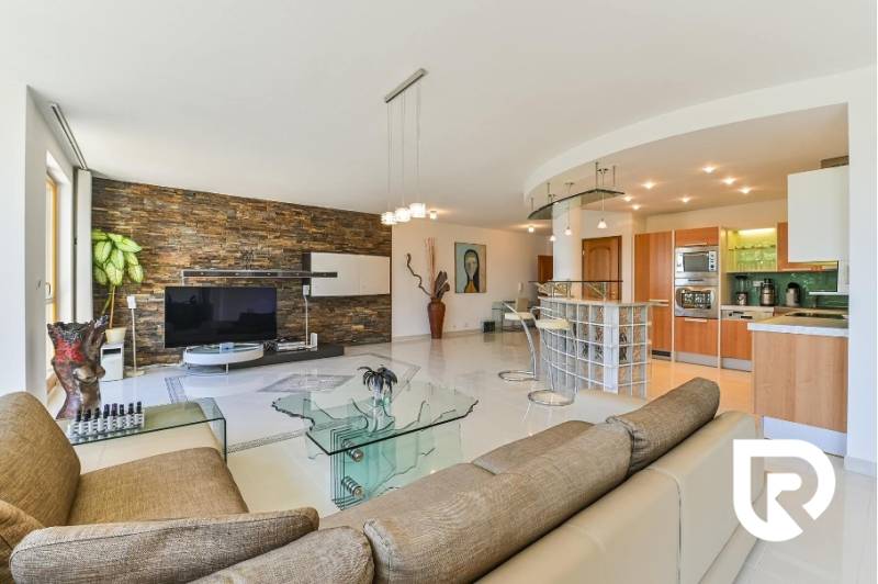 Staré Mesto | 5i byt 175 m² + 4 balkóny + možnosť 2× parking - Priestranný obývací priestor s kuchyňou, skleneným stolíkom a kamennou stenou v 4-izbovom byte.