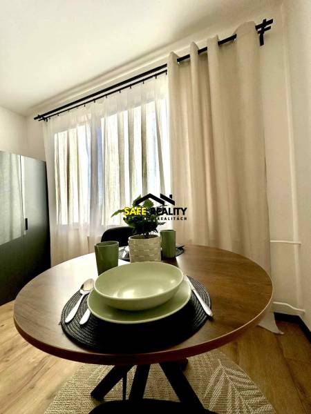 REZERVOVANÝ PREDAJ 1-izbový byt, Vlčince - okr. Žilina - Jeden zútulnený kút 1-izbového bytu s okrúhlym stolom a riadom.