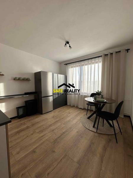 REZERVOVANÝ PREDAJ 1-izbový byt, Vlčince - okr. Žilina - Kuchyňa s podlahou s dreveným dekorom a stolom v 1-izbovom byte.