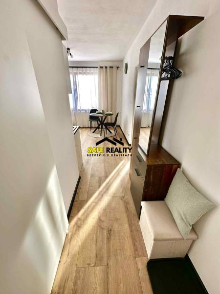 REZERVOVANÝ PREDAJ 1-izbový byt, Vlčince - okr. Žilina - Jasný interiér s jedálenským stolom a podlahou s dreveným dekorom v 1-izbovom byte.