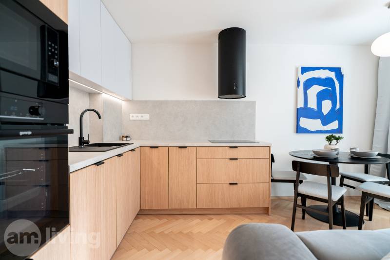 3i BYT V TOP LOKALITE – Trenčín, Sihoť - NA PRENÁJOM - Kuchyňa s podlahou s dreveným dekorom, drevenými skrinkami a jedálenským stolom v 3-izbovom byte.