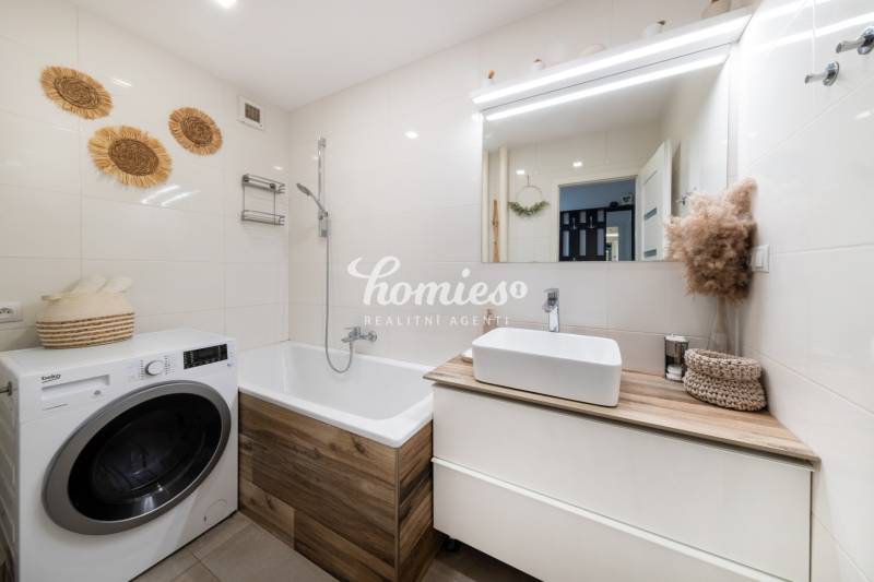 PREDAJ 2 izbový moderne zrekonštruovaný byt s klimatizáciou, CENTRUM - Kúpeľňa v 2-izbovom byte s práčkou a vaňou, svetlé obklady a dekorácie.