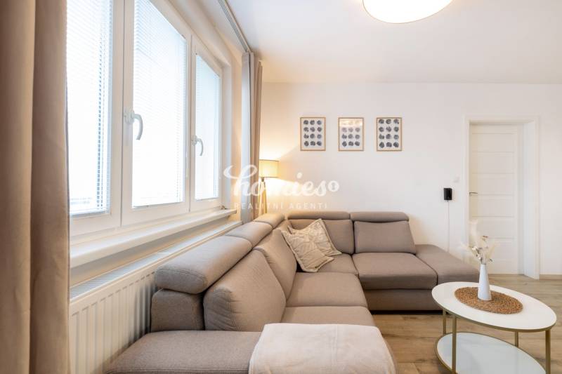 PREDAJ 2 izbový moderne zrekonštruovaný byt s klimatizáciou, CENTRUM - Obývacia izba v 2-izbovom byte s pohodlnou sedačkou a dekoráciami na stene.