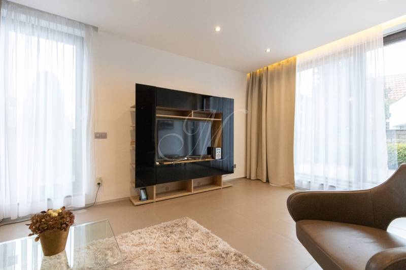 Exkluzívny 2i byt s terasou a parkovaním, Kramáre - Obývacia izba v 2-izbovom byte so svetlými závesmi a televíznou stenou.