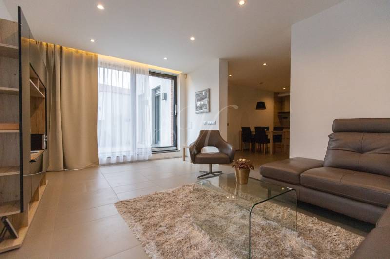 Exkluzívny 2i byt s terasou a parkovaním, Kramáre - Obývačka v 2-izbovom byte s pohodlnou sedačkou, kreslom a sklom stolíkom.