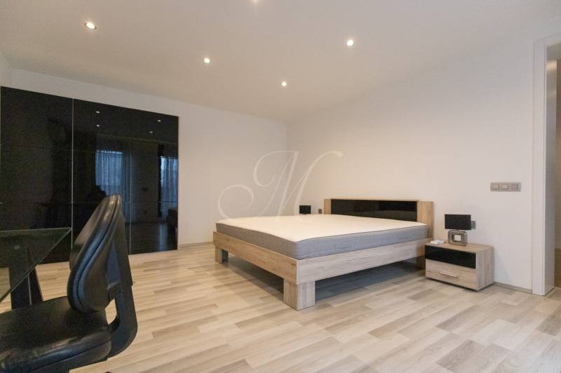 Exkluzívny 2i byt s terasou a parkovaním, Kramáre - 2-izbový byt s podlahou s dreveným dekorom, posteľou, skriňou a kancelárskou stoličkou.