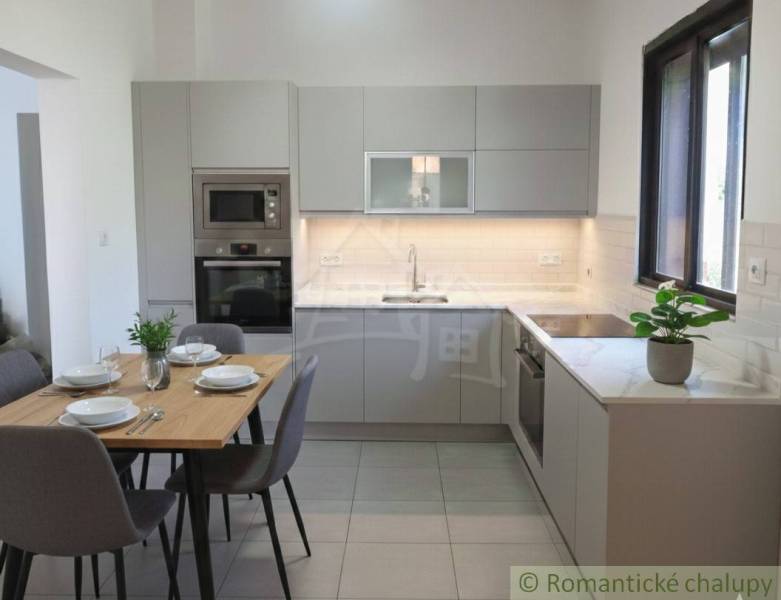 Rodinný dom v srdci Štiavnických vrchov, Štiavnické Bane. - Kuchyňa v rodinnom dome so sivou linkou a jedálenským stolom so štyrmi stoličkami.