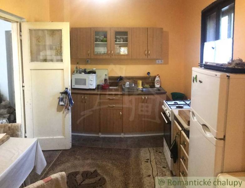 Rodinný dom v srdci Štiavnických vrchov, Štiavnické Bane. - Kuchyňa v rodinnom dome s dreveným dekorom a základným vybavením.