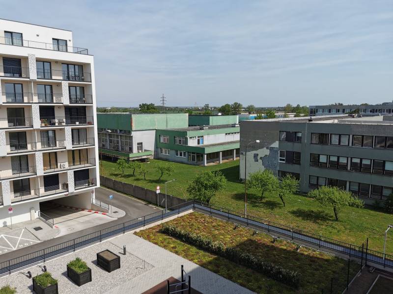 PRENÁJOM parkovacieho miesta v garáži, E.Wenzla - RENDEZ - Pohľad na obytné budovy a zeleň na Eduarda Wenzla v Bratislave-Rači, garáže vpravo.