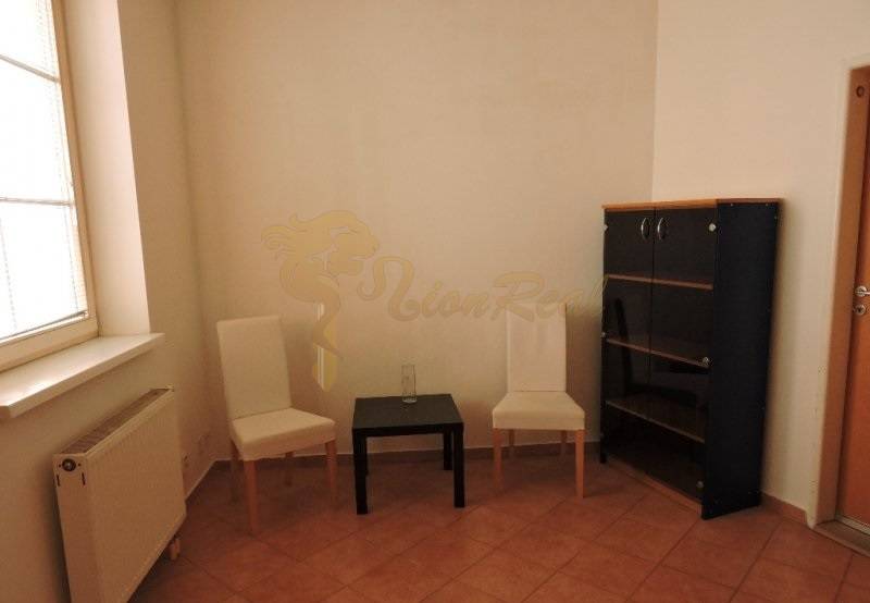 Nebytový priestor, Mikulášska, centrum mesta pod hradom - Na ulici Mikulášska, 1-izbový byt s dvoma stoličkami a skrinkou v miestnosti.