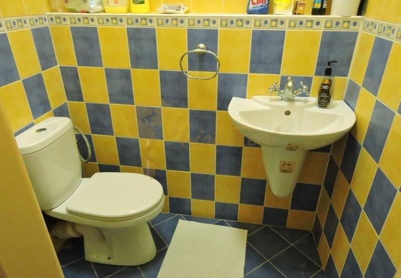 Nebytový priestor, Mikulášska, centrum mesta pod hradom - Kúpeľňa v 1-izbovom byte s modro-žltými kachličkami na ulici Mikulášska.