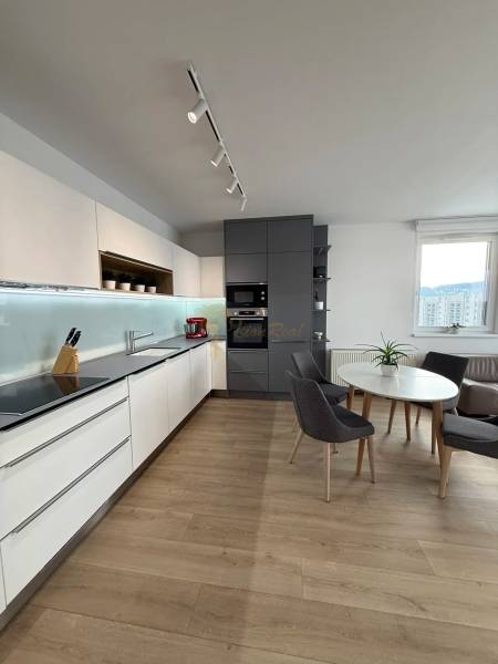 3-izb. byt, Martina Granca, Dúbravka, novostavba Pekná výhliadka - Kuchyňa v 3-izbovom byte s podlahou s dreveným dekorom a jedálenským stolom.