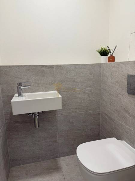 3-izb. byt, Martina Granca, Dúbravka, novostavba Pekná výhliadka - Malé WC so stenami z dlaždíc a závesným umývadlom v 3-izbovom byte.