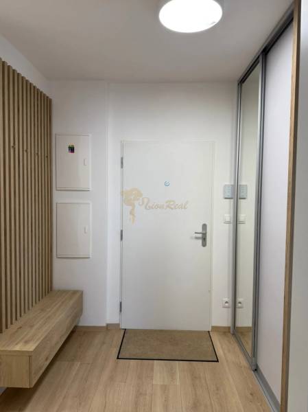 3-izb. byt, Martina Granca, Dúbravka, novostavba Pekná výhliadka - Vstupná chodba s bielymi dverami, zrkadlovou skriňou a podlahou s dreveným dekorom v 3-izbovom byte.