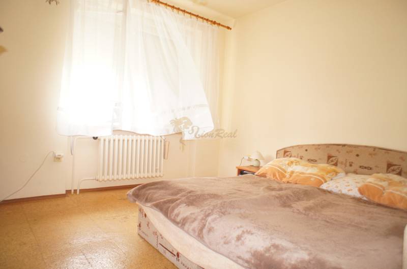 Rodinný dom v obci Čilížska Radváň s veľkým pozemkom - Spálňa v rodinnom dome, osvetlená oknom, s posteľou a radiátorom.