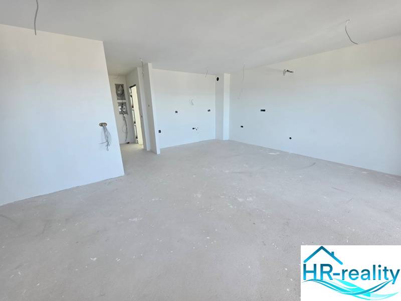 Chorvátsko, Makarska - veľký apartmán v novostavbe s výťahom - Rekreačný apartmán s čistými bielymi stenami a priestrannou podlahou s dreveným dekorom.