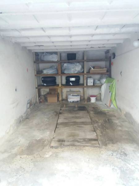 Garáž na ul. Jelačičova, Ružinov - Nivy - Úložný priestor v garáži s regálmi plnými rôznych predmetov a nástrojov.