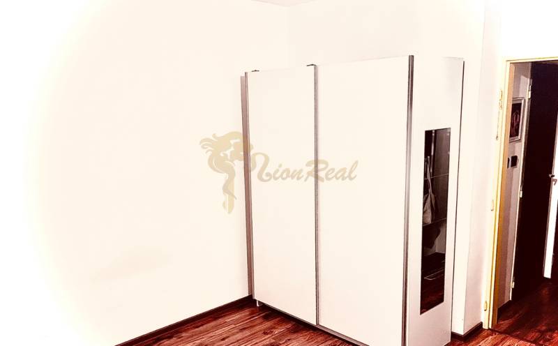 Garzónka M. Schneidra Trnavského, Dúbravka, veľká lodžia - V garsónke je umiestnená biela vstavaná skriňa a podlaha s dreveným dekorom.