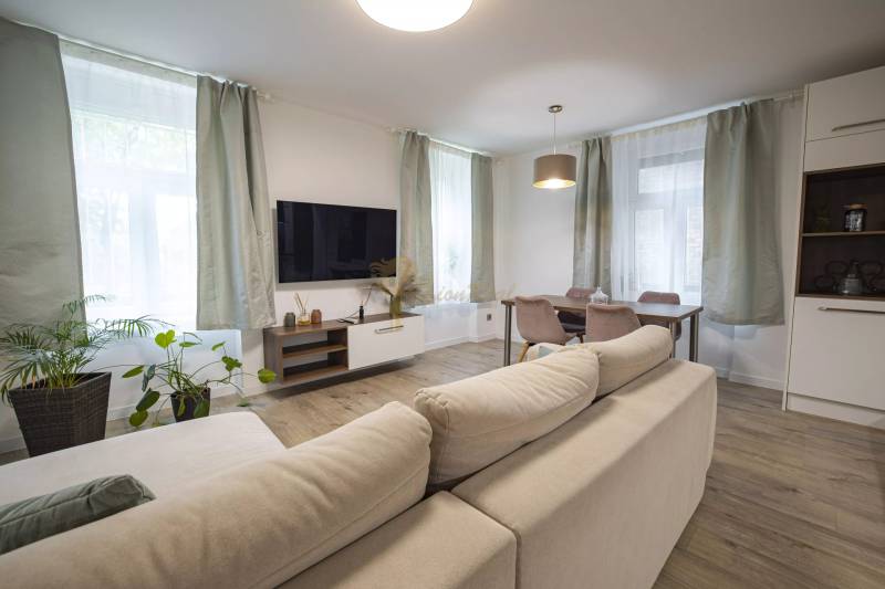 2,5 izb. byt, ul. Jelenia, Staré Mesto,tehlový dom, po rekonštrukcii - Svetlá obývačka s pohodlným gaučom a televíziou v 3-izbovom byte na ulici Jelenia.