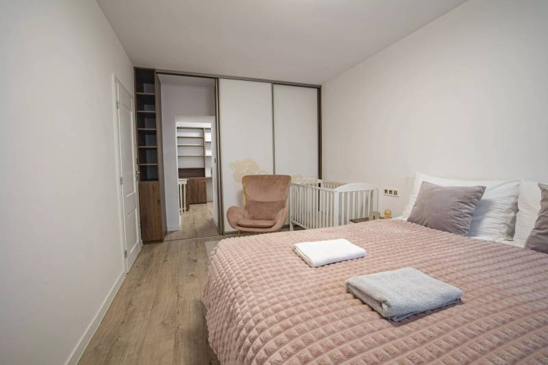 2,5 izb. byt, ul. Jelenia, Staré Mesto,tehlový dom, po rekonštrukcii - Spálňa v 3-izbovom byte na ulici Jelenia, biela posteľ, komoda s úložným priestorom.