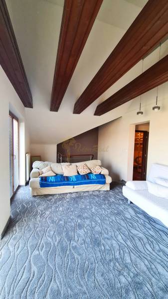 5-izb. dvojpodlažný rodinný dom, Rovinka - Obývacia izba s drevenými trámami a pohovkami v rodinnom dome.