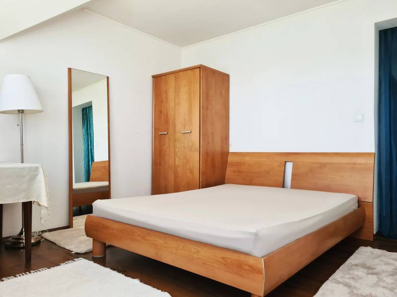 5-izb. dvojpodlažný rodinný dom, Rovinka - Spálňa v rodinnom dome s drevenou posteľou, skriňou, zrkadlom a stojacou lampou.