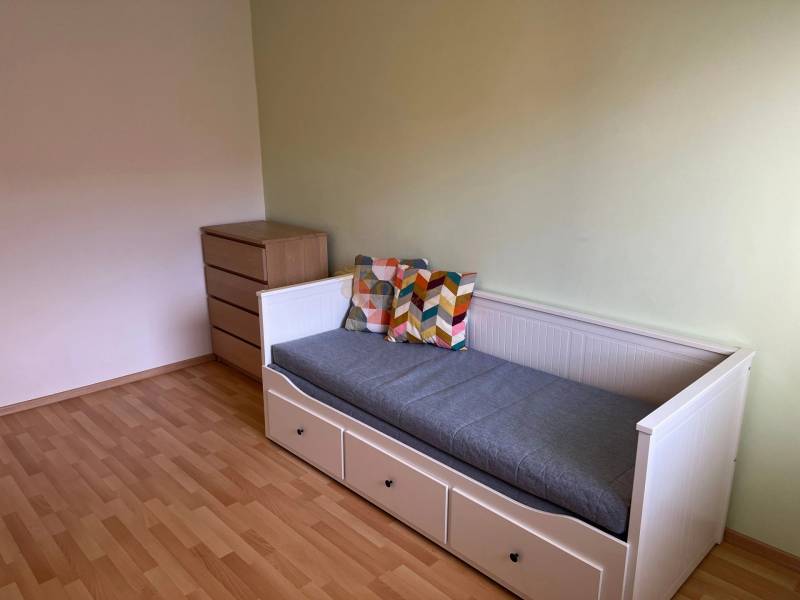 3-izb. byt, Palkovičova ul., Ružinov, lodžia, 4.p./12 - Izba v 3-izbovom byte s posteľou, komodou a podlahou s dreveným dekorom.