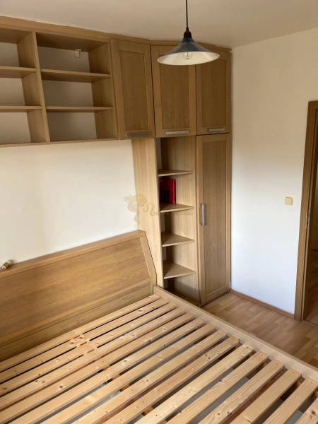 3-izb. byt, Palkovičova ul., Ružinov, lodžia, 4.p./12 - Spálňa v 3-izbovom byte s posteľou, skriňami a podlahou s dreveným dekorom.