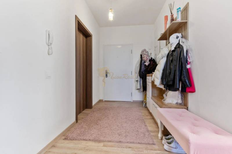 Novostavba 3-izb. bytu s parkovacím státím, ul.Hany Ponickej, Lamač - Chodba s vešiakmi a ružovým kobercom v 3-izbovom byte s podlahou s dreveným dekorom.