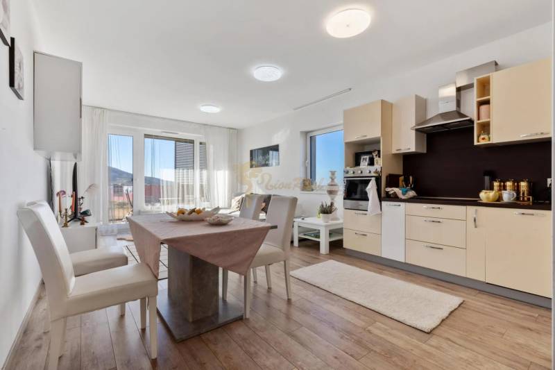 Novostavba 3-izb. bytu s parkovacím státím, ul.Hany Ponickej, Lamač - Jedálenská časť v 3-izbovom byte s kuchynskou linkou a podlahou s dreveným dekorom.