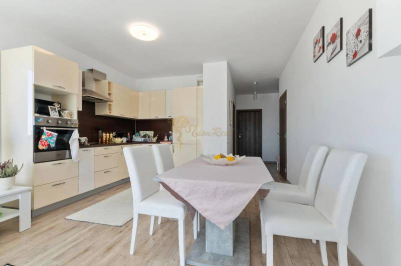 Novostavba 3-izb. bytu s parkovacím státím, ul.Hany Ponickej, Lamač - Kuchyňa v 3-izbovom byte s podlahou s dreveným dekorom a jedálenským stolom.