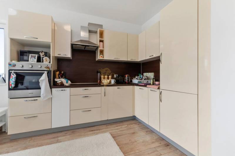 Novostavba 3-izb. bytu s parkovacím státím, ul.Hany Ponickej, Lamač - Kuchynská linka v 3-izbovom byte s podlahou s dreveným dekorom a vstavanými spotrebičmi.