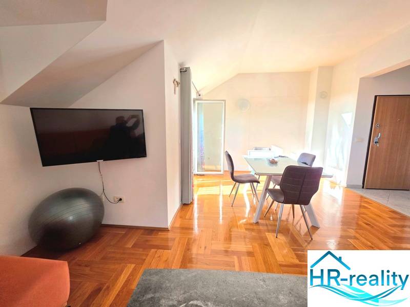 Chorvátsko, Makarska - zariadený apartmán s výhľadom na more - Interiér rekreačného apartmánu s podlahou s dreveným dekorom a jedálenským stolom.