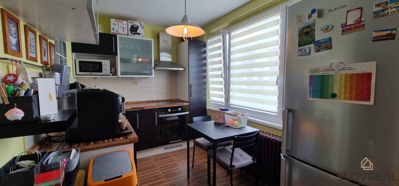 Predaj 2i byt v meste Kremnica, 64m2 - Kuchyňa v 2-izbovom byte s tmavou linkou a podlahou s dreveným dekorom.