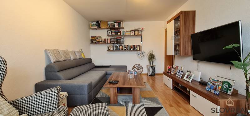 Predaj 2i byt v meste Kremnica, 64m2 - Obývacia izba v 2-izbovom byte s pohovkou a policami na knihy.