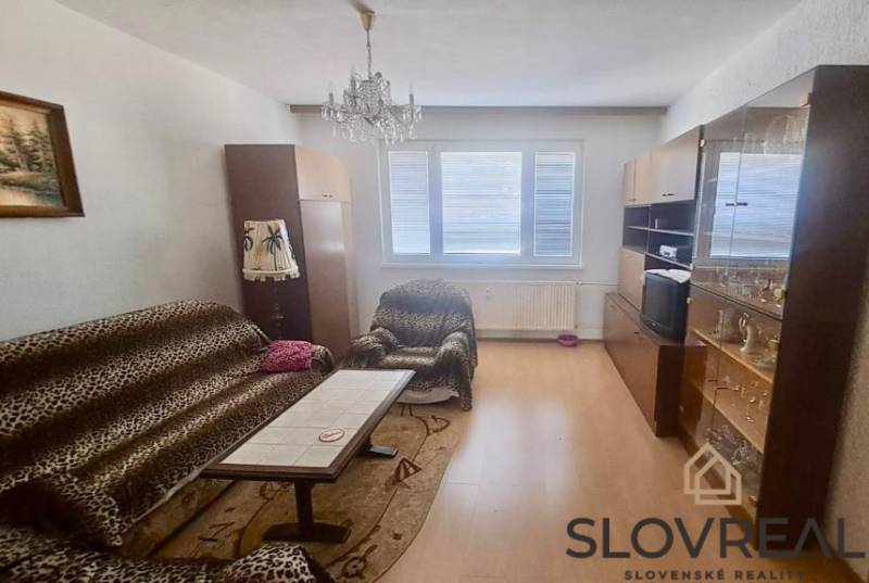 PREDAJ 2 IZBOVÝ BYT HANDLOVÁ  - Obývačka v 2-izbovom byte so sedačkou, konferenčným stolíkom a skriňou.