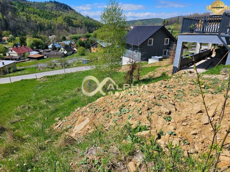 Stavebný pozemok lokalita Slnečná úboč, Levočská Dolina, okres Levoča - Pozemky - bývanie v Levoči s domami na svahovitej krajine, obklopené zeleňou.