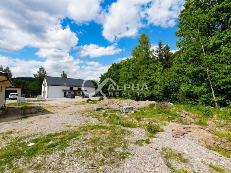 EXKLUZÍVNE Stavebný pozemok, 916m2, Novoveská Huta - Pozemky - bývanie v Spišskej Novej Vsi. Budovy pri lese, štrk, modrá obloha.