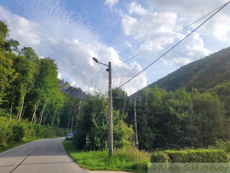 Stavebný pozemok pod lesom končiaci potôčikom v krásnom prírodnom pros - Cesta obklopená lesom, elektrické stĺpy, Beluša, Pozemky - bývanie.