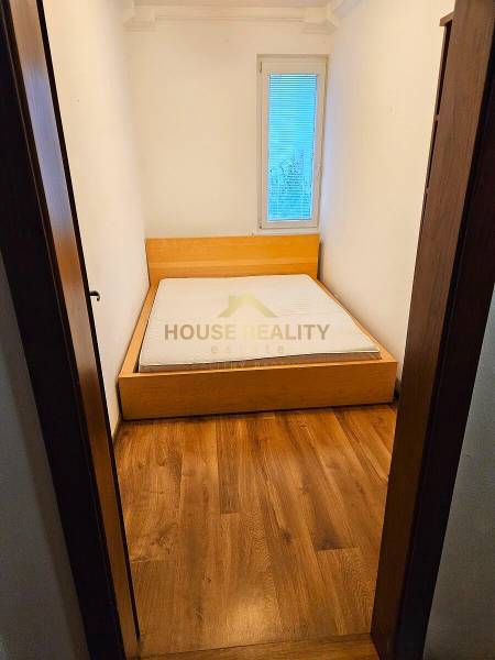 Prenájom pekný 3 izbový byt, Haburská ulica, Bratislava II. Ružinov - Spálňa v 3-izbovom byte s posteľou a podlahou s dreveným dekorom.