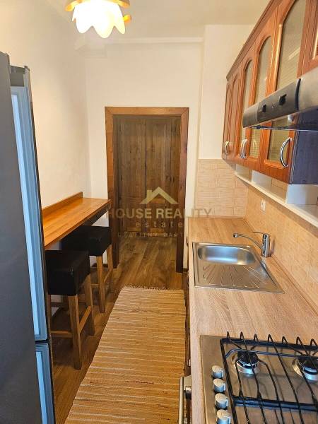 Prenájom pekný 3 izbový byt, Haburská ulica, Bratislava II. Ružinov - Kuchyňa v 3-izbovom byte s podlahou s dreveným dekorom, barovým pultom a spotrebičmi.