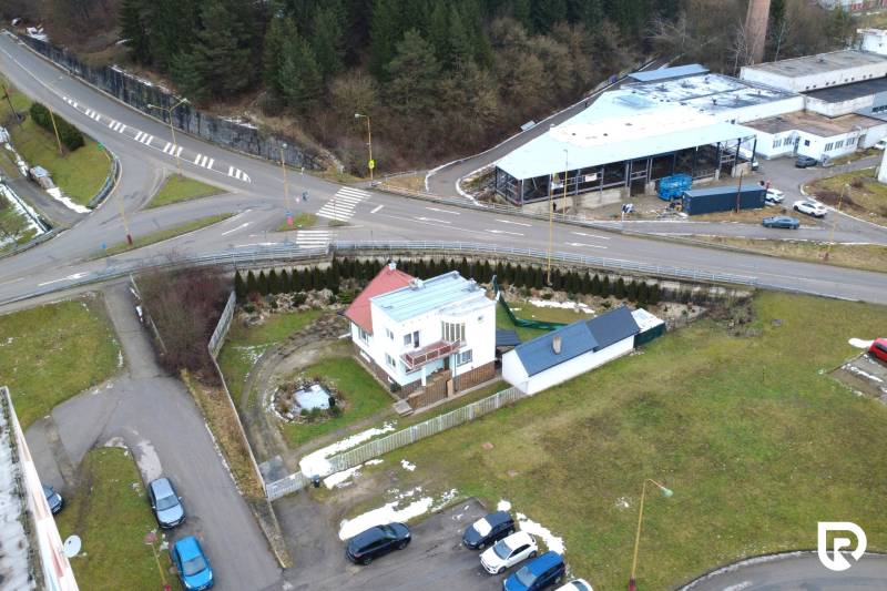 Na predaj dom vhodný na podnikanie sídlisko SNP v P. Bystrici! - Rodinný dom na ulici SNP v Považskej Bystrici, obklopený zelenými plochami a križovatkou.