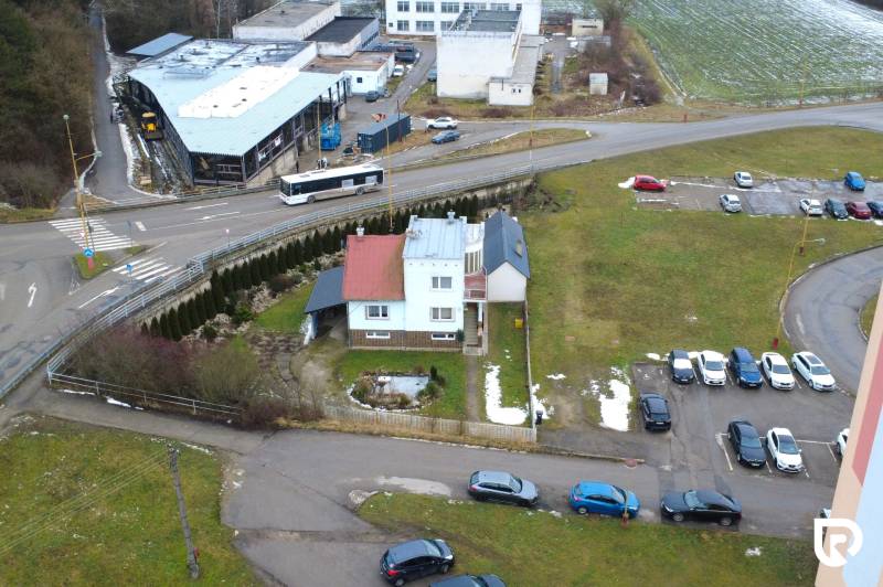 Na predaj dom vhodný na podnikanie sídlisko SNP v P. Bystrici! - Rodinný dom na ulici SNP v Považskej Bystrici, obklopený autami a zeleňou.