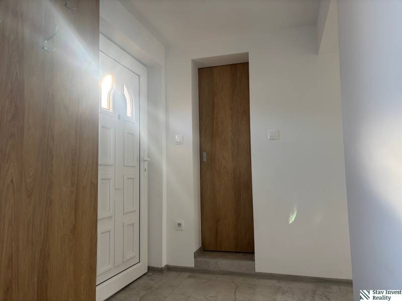 Prenájom komplet prerobený a zariadený  RD 3 izb. Blatné  - Interiér rodinného domu s bielymi dverami a podlahou s dreveným dekorom.