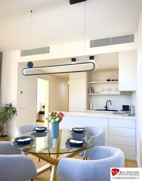 Prenájom 3-izbový byt s loggiou, SKY PARK, Bratislava - Jedálenský kút s presvetleným skleneným stolom, štyrmi stoličkami a kuchyňou v 3-izbovom byte.