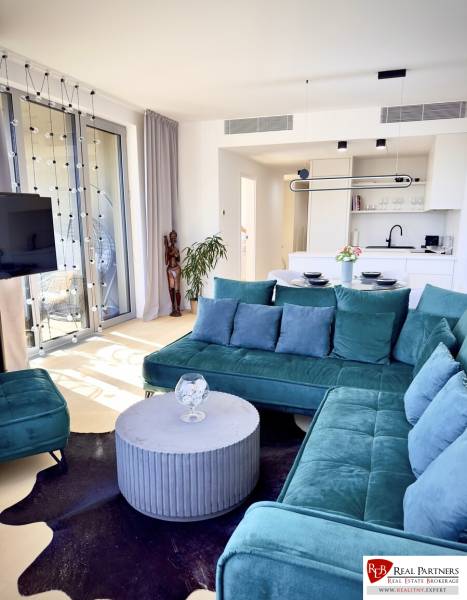 Prenájom 3-izbový byt s loggiou, SKY PARK, Bratislava - Obývacia izba v 3-izbovom byte so zelenou sedačkou a kuchynským kútom.