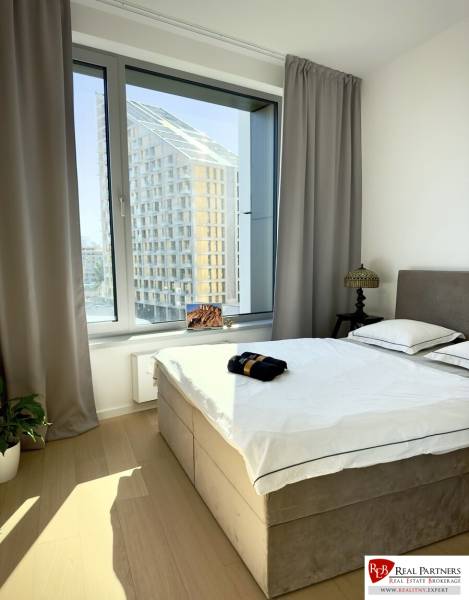 Prenájom 3-izbový byt s loggiou, SKY PARK, Bratislava - Spálňa v 3-izbovom byte so svetlými závesmi a podlahou s dreveným dekorom.