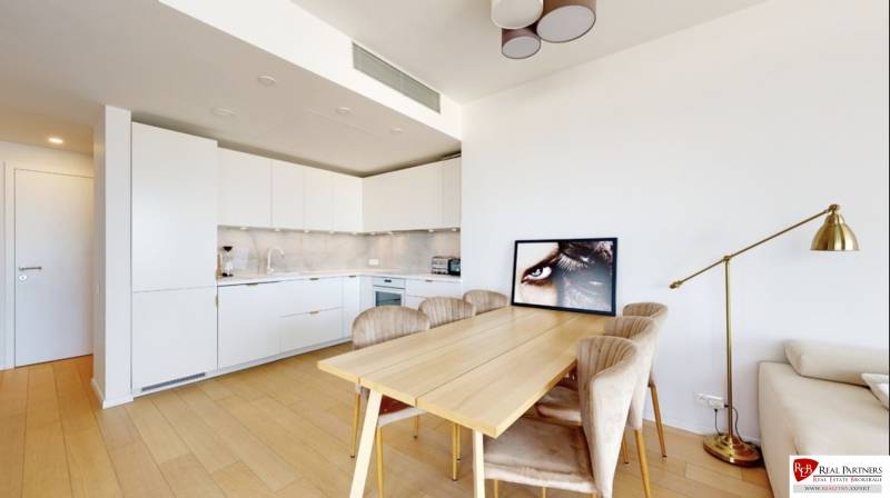 Prenájom 3-izbový byt s terasou, SKY PARK, Bratislava - Kuchyňa v 3-izbovom byte s podlahou s dreveným dekorom, jedálenským stolom a lampou.