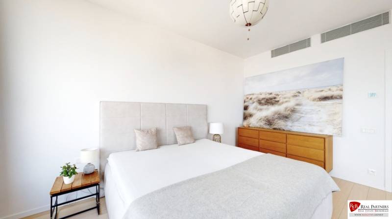 Prenájom 3-izbový byt s terasou, SKY PARK, Bratislava - Spálňa v 3-izbovom byte s veľkou posteľou, obrazom a drevenou komodou.