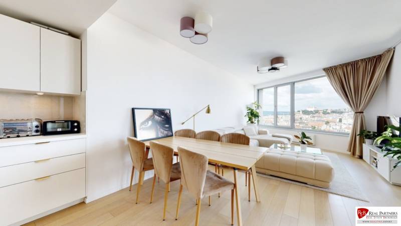 Prenájom 3-izbový byt s terasou, SKY PARK, Bratislava - Svetlá obývačka s jedálenským stolom, bielou sedačkou a výhľadom, 3-izbový byt.